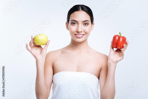 Pleasant woman posing with apple and bell pepper