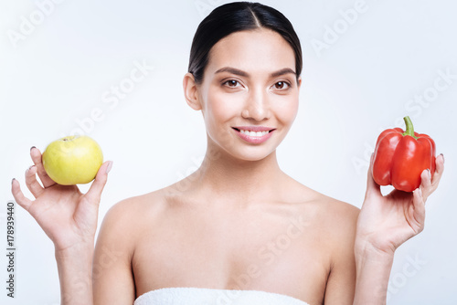 Upbeat woman posing with bell pepper and apple