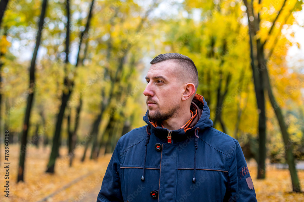 man walks in the autumn park. portrait of a man a look into the sky man walks in the autumn park. portrait of a man a look into the sky