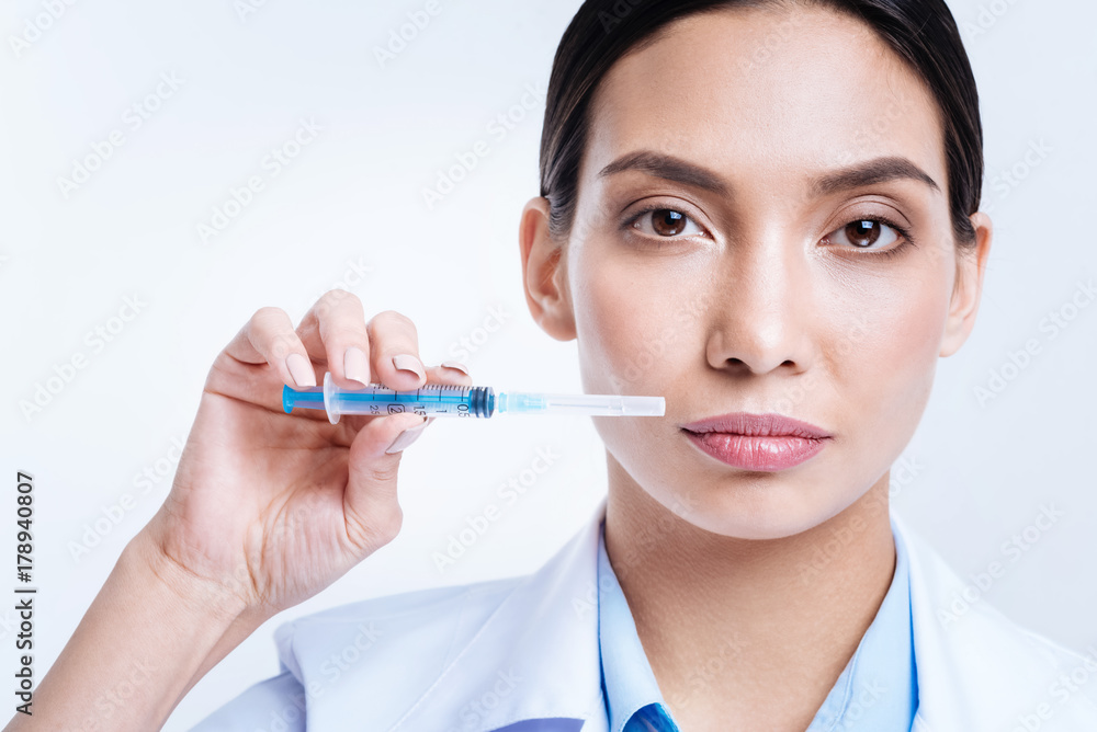 Close up of beautiful female doctor holding a syringe Close up of beautiful female doctor holding a syringe