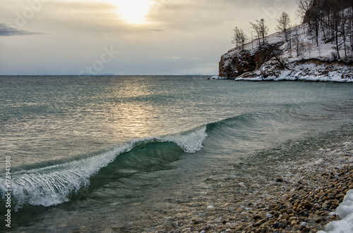 Waves and splash on Lake Baikal with rocks and trees in Uzuri bay photo