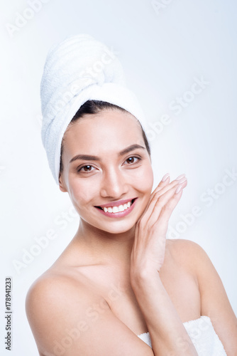 Upbeat young woman smiling while posing in towel turban