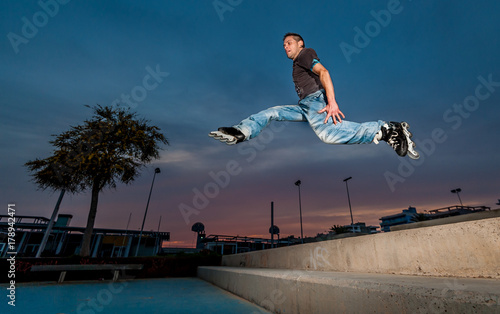 inline skater man jumps in the street