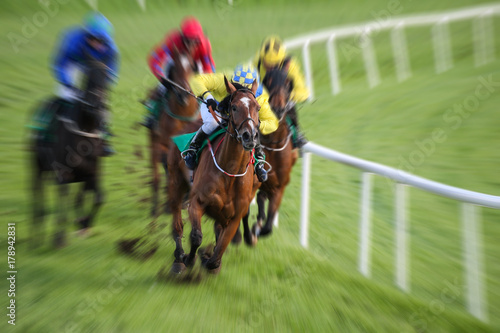 Race horses and jockeys racing motion blur
