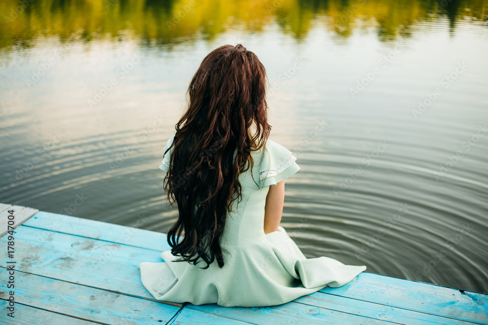 girl in vintage clothes loose hair near the water