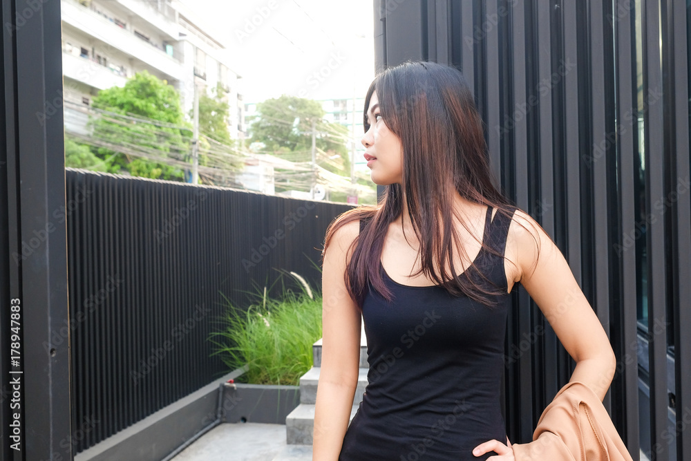 Asian women stand on modern building in black suit Asian women stand on modern building in black suit