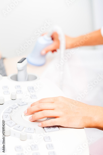 Doctor operating ultrasound machine performing obstetric ultrasonography