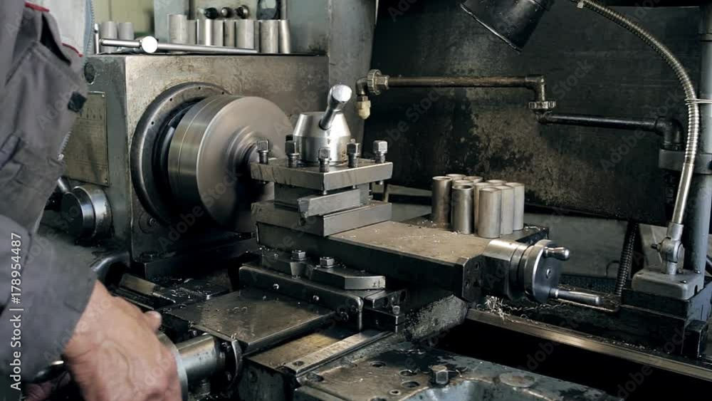 The man is working for the milling machine The man is working for the milling machine