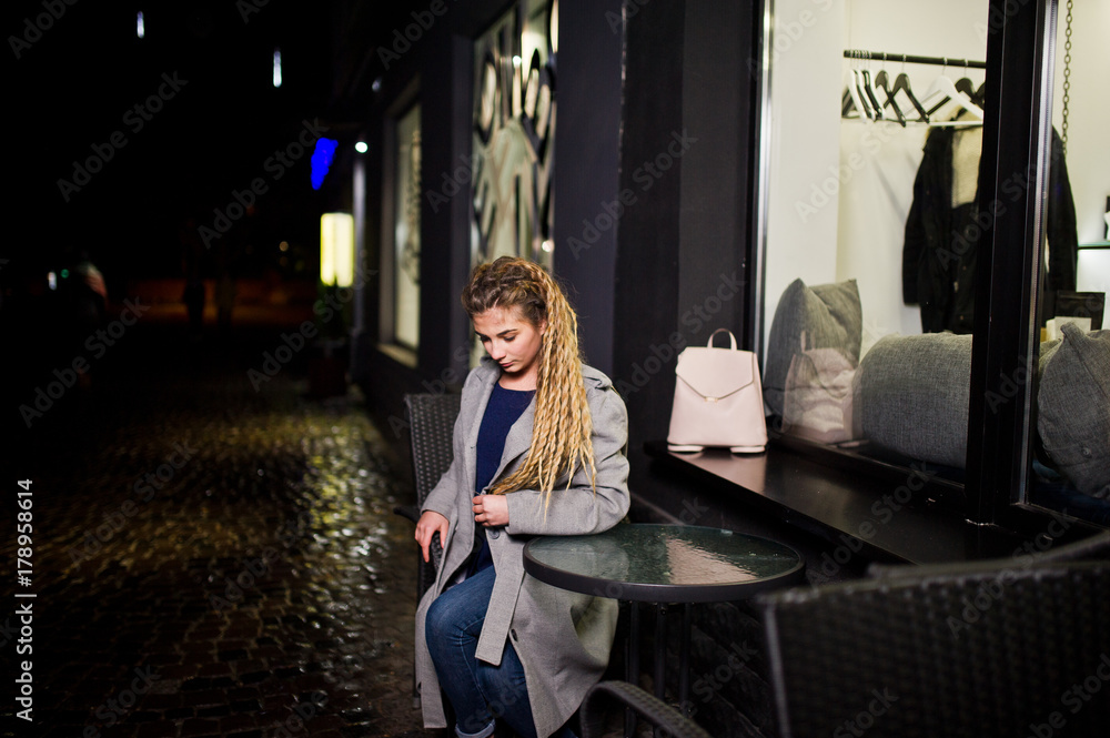 Girl with dreadlocks walking at night street of city. Girl with dreadlocks walking at night street of city.