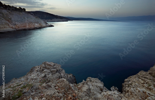 sea with rocky shore in sunset light