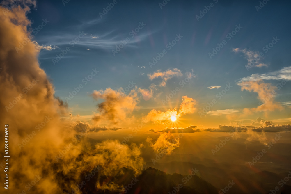 Obraz premium Beautiful mountain sky and clouds with golden light at sunset. subject is blurred.