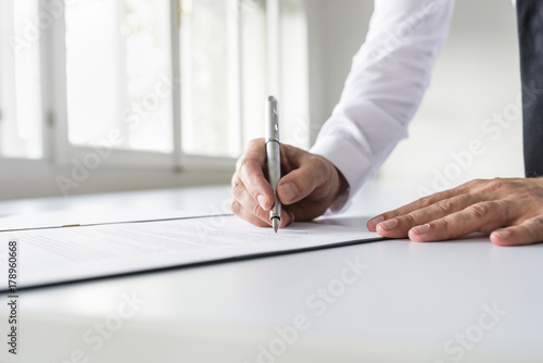 Businessman in white shirt signing contract photo