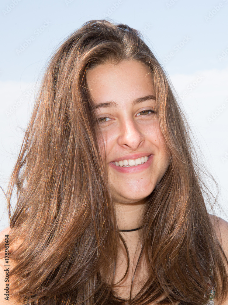 Happy woman with a lovely smile standing on a sea promenade in summer Happy woman with a lovely smile standing on a sea promenade in summer