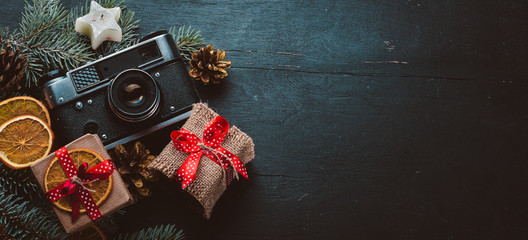Camera Christmas wooden background. New Year's holiday. Christmas motive. On a wooden surface. Top view. Free space for your text.