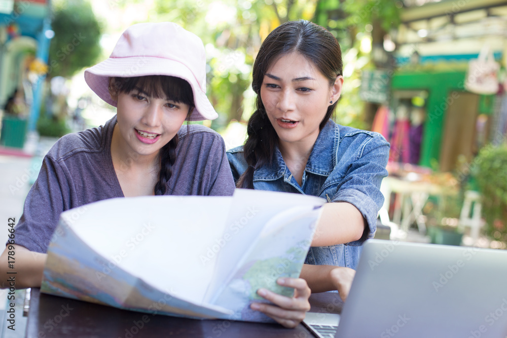 Portrait of Happy traveler Woman in city. Asian women using Map and Laptop for seach location, People with Traveler Concept. Portrait of Happy traveler Woman in city. Asian women using Map and Laptop for seach location, People with Traveler Concept.