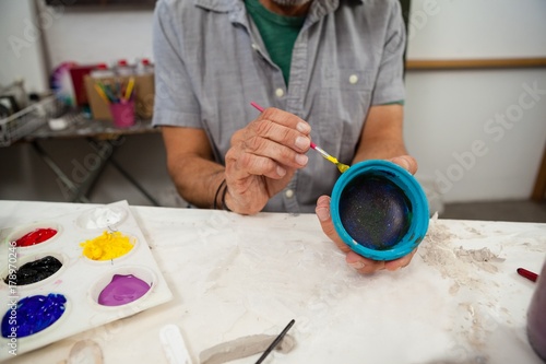 Mid section of man painting bowl