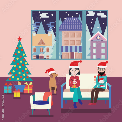 Couple at home sitting on sofa in the christmas living room.