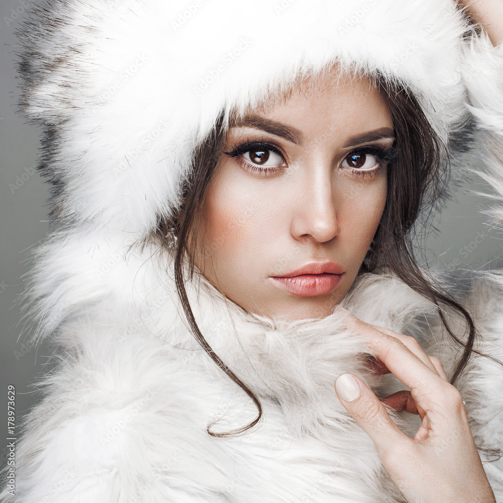 Beautiful woman in white fur coat and fur hat