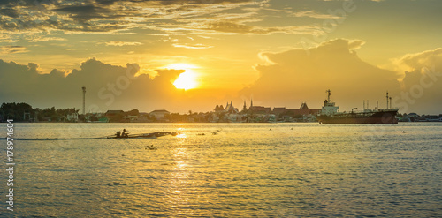 Panorama of the mouth of the Tha Chin River in the evening with cargo boats and fishing boats parked.
