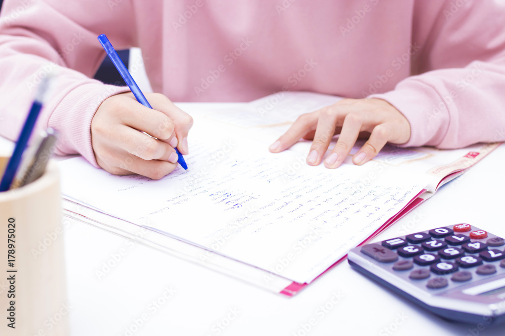 student hand writing with calculator at home or school student hand writing with calculator at home or school