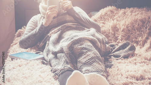 A girl with a cup of naya lies under a blanket. Recreation. Selective focus.   photo