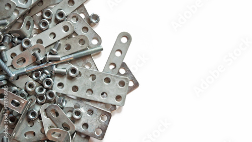 Details of silvery metal children's designer isolated on white background. Bolts, screws and nuts for assembly photo