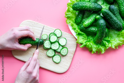 Cut fresh cucumbers. Pink background top view