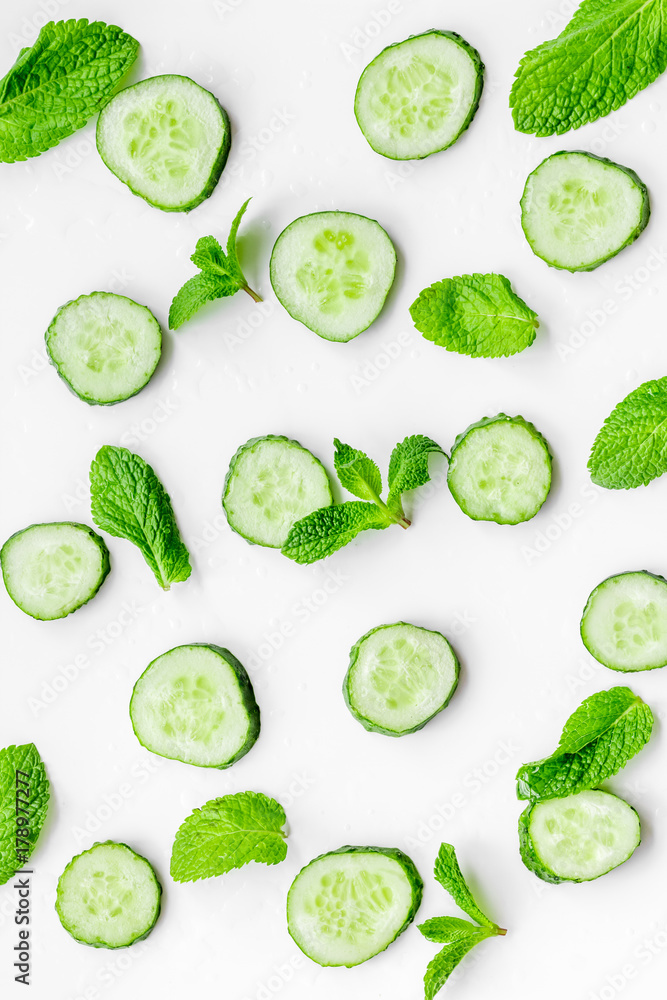 Skin care at home. Sliced cucumber pattern on white background top view Skin care at home. Sliced cucumber pattern on white background top view