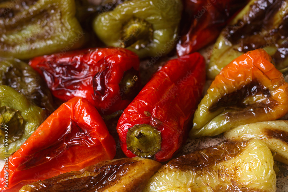 Baked bell peppers of different colors with vegetable oil and herbs on a baking sheet. Baked bell peppers of different colors with vegetable oil and herbs on a baking sheet.