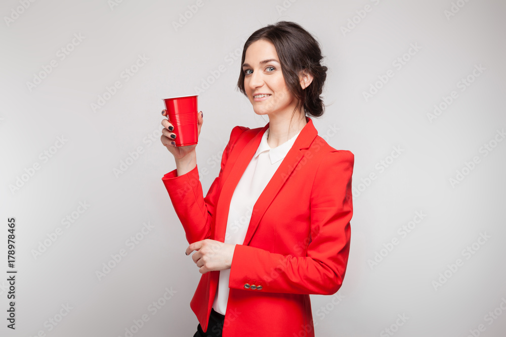 Picture of attractive woman in red dress with cup of beer in hands Picture of attractive woman in red dress with cup of beer in hands