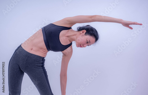 Beautiful young Asian doing yoga exercise. Healthy young girl practicing yoga. Healthy lifestyle and good wellness concepts