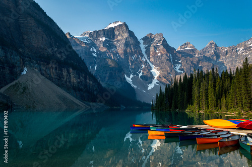 A row of canoes sitting in the evening sun, ready to be taken on the water. Louise lake in Banff national park, Alberta, Canada