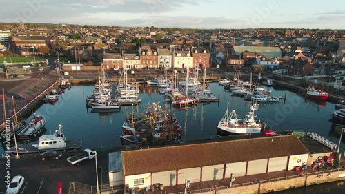 Aerial shot of Arbroath Harbour, Scotland. Tracking shot of fishing boat leaving harbour