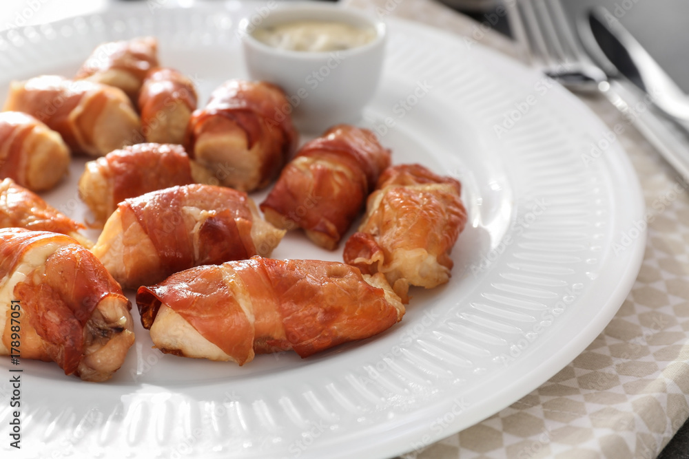 Bacon wrapped chicken on plate, closeup Bacon wrapped chicken on plate, closeup