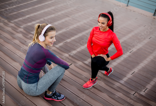 Two young women exercise outside