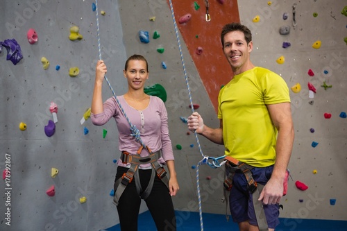 Portrait of athletes holding rope while standing by climbing