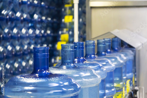 Behang Blue water plastic bottles on conveyor