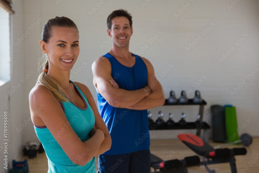 Portrait of confident athletes with arms crossed standing in gym Portrait of confident athletes with arms crossed standing in gym