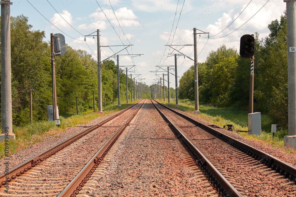 railroad tracks with red stones and semaphore in summer in Europe railroad tracks with red stones and semaphore in summer in Europe