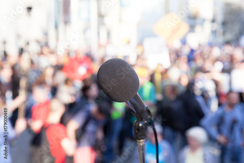 Protest. Public demonstration. Microphone in focus against blurred crowd. © wellphoto