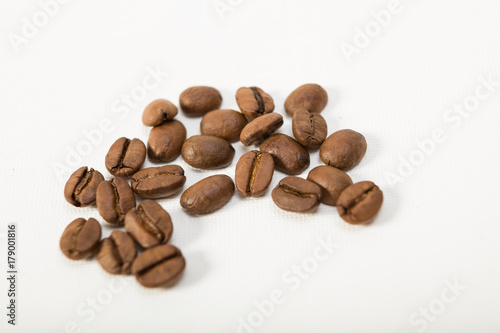 macro image of dark aromatic coffee beans on white background with copy space.