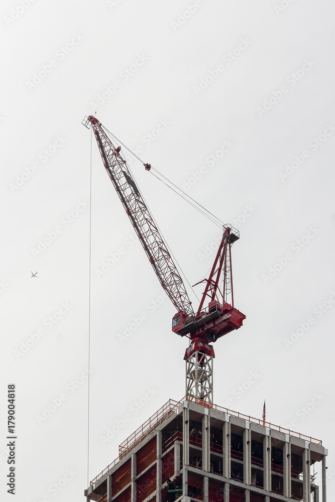  A crane sits on top of a building being constructed in central manhattan.