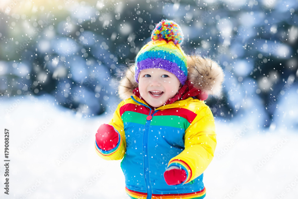Child playing with snow in winter. Kids outdoors. Child playing with snow in winter. Kids outdoors.