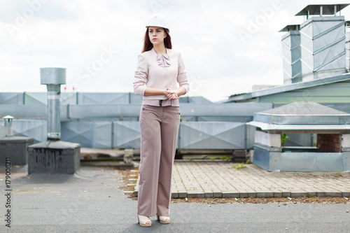 Pretty businesswoman in beige suit stand on the roof