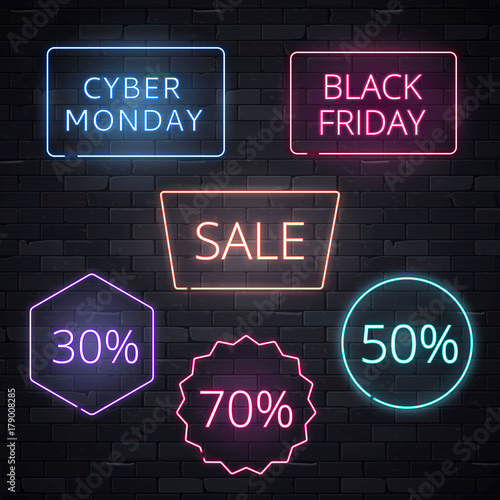 Set of sale signs neon frame light electric banners glowing on black brickwall background.Black friday Cyber monday 70 50 30 sale billboards