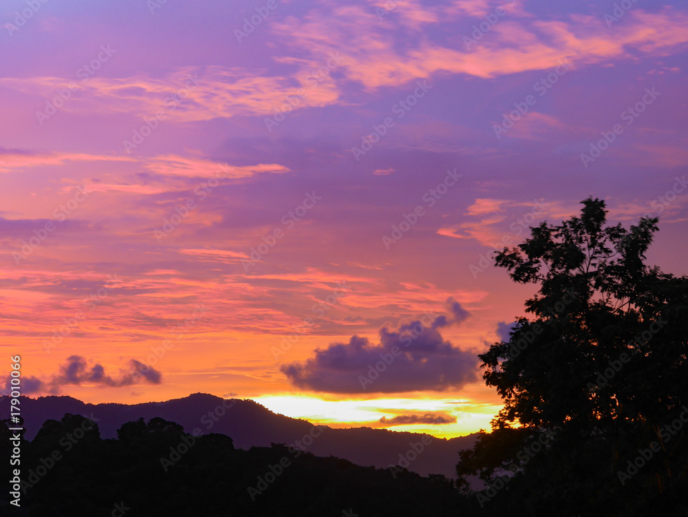Twilight beautiful evening cloudy sky after sunset background . There are silhouette mountains and trees. Twilight beautiful evening cloudy sky after sunset background . There are silhouette mountains and trees.