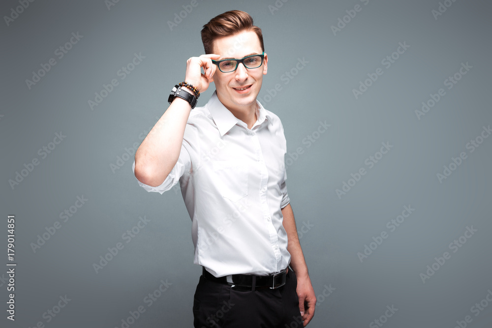 Young attractive businessman in costly watch, black glasses and white shirt Young attractive businessman in costly watch, black glasses and white shirt