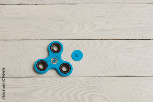 Blue fidget spinner stress relieving toy on wooden background