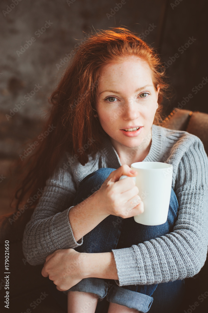 happy young readhead woman drinking hot coffee or tea at home. Calm and cozy weekend in winter or autumn happy young readhead woman drinking hot coffee or tea at home. Calm and cozy weekend in winter or autumn