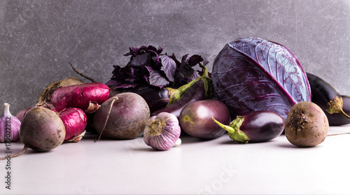 Assortment of Purple and Red vegetables on a stone background.